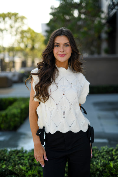CABLE KNIT SCALLOPED VEST WITH CONTRAST SIDE BOW - CREAM